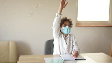 Schoolboy boy in the classroom holds his hand up, ready to answer the teachers question. Children teenagers in school in