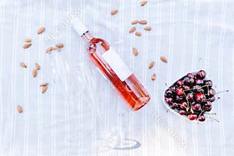 Rose wine bottle with glasses and cherry picnic background