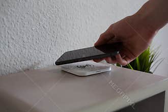 Smartphone being placed on wireless charging pad to charge