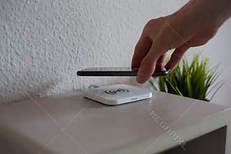 Smartphone being placed on wireless charging pad to charge battery