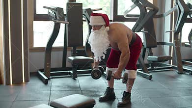 Strong fitness man doing dumbbell swings at gym. Strongman workout in sport club