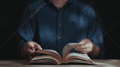 Spirituality and Religion Concept, Person Sitting on Desk to Making Pray on a Holy Bible in Church or House. Believe and Faith for