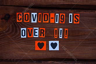 COVID-19 is over paper letters sign on wooden background. Opening borders between countries. End of Quarantine news
