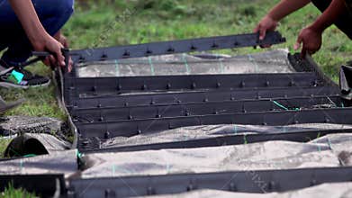 Young children constructing a path, laying delimiter panel