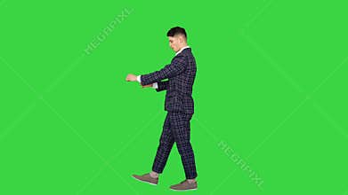 Young cool elegant man walking by on a Green Screen, Chroma Key.