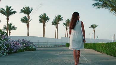 Teenage girl walking at exotic park. Young woman enjoying summer vacation.