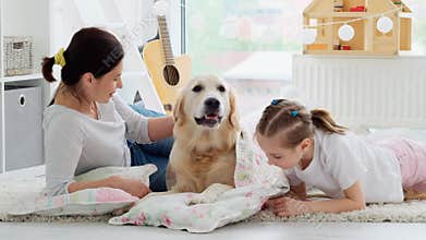 Mother and daughter palming dog on bedding
