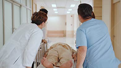 Group of Asian emergency doctor and nurse team wear face mask, push emergency stretcher, transport senior patient in hospital
