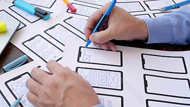 The designer draws the web interface of new web application for the smartphone.