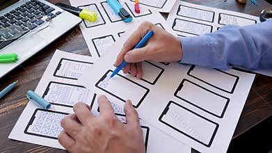 Man is designing ux user experience design for mobile app for a startup.