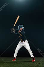 Baseball player with bat on dark background. Ballplayer portrait.