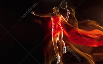 Professional female tennis player isolated on black studio background in mixed light