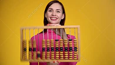 Young attractive girl holds wooden abacus in her hands.