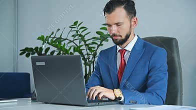 Businessman Sitting In Office And Typing On Laptop