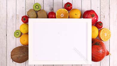 White frame with place for text and moving fruits and vegetables under frame. Stop motion