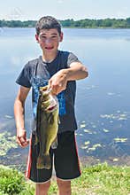 Boy Holding a Large Mouth Bass Fish by Lake