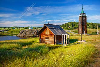 Russian countryside with old log house and fire tower