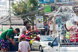 Thai family splashing water on Songkran festival