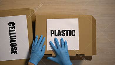 Person giving worker boxes with plastic and cellulose disposables, waste sorting