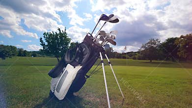 A set of golfing clubs on a field.