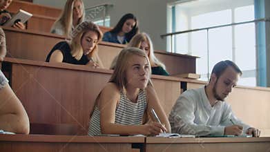 A group of students at the university listen and record a lecture at the teacher