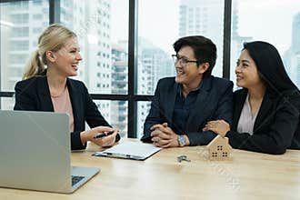 Salesmen are letting the male customers sign the sales contract, caucasian women and couple are doing business in the office,