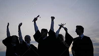 Celebration Education Graduation Student Success Learning Concept. Silhouette of students tossing caps in the air.