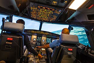 Modern airbus airplane cockpit with pilots during a training session in a full flight simulator