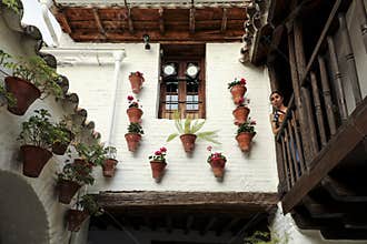 A young woman looks out at the railing of a Cordovan patio.