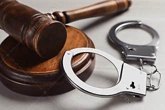 Judge`s gavel and handcuffs on white wooden background. Criminal law concept