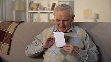 Crying senior widower holding photo, missing wife after funeral, lost family