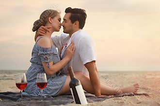 Happy young couple having picnic at sea