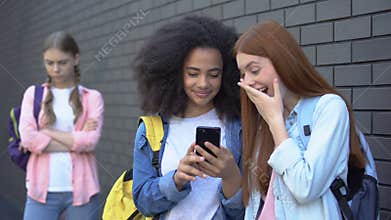 Cruel teenagers bullying female classmate by smartphone, cyber abuse, conflict