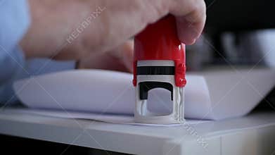 Manager Stamping Some Papers and Documents Using a Rubber Stamp in Slow Motion