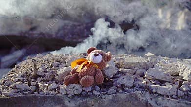 Concept idea of disaster victims ,toy bear falls on the background of Smoking ruins