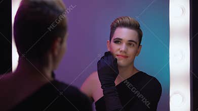 Trans man looking at half-face makeup in mirror, accepting female inner self