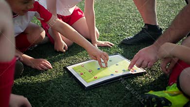 Junior football team coach explains game tactic