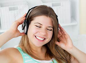 Cheerful woman listening to music with headphones