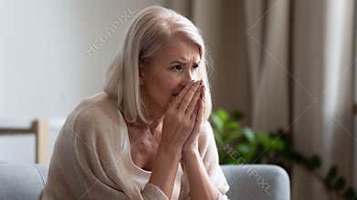 Upset mature woman crying, sitting alone, feeling lonely and unwell