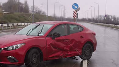 Car accident on the road during the rain. Red damaged car on an empty road.