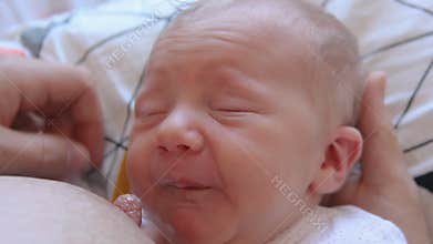 Mother Holding Newborn in Embrace and Breastfeed Her Infant, Close-up View of Baby Head, Tenderness and Care of Motherhood.