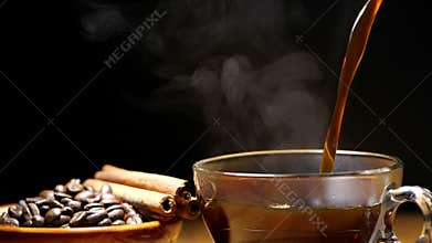 Pouring black coffee in a cup with steam in slow motion