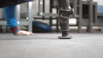 The athlete with a prosthetic arm is pushing out. Does exercise on the floor while lying. Professional prosthetic arm