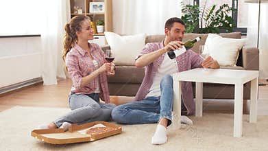 Couple with wine and takeaway pizza at home