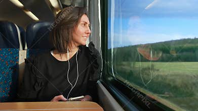 Woman listens to a player and goes on a train in Europe