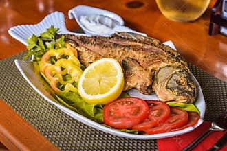 Fried crucian carp fish on a decorated plate