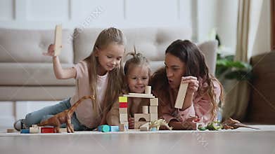 Happy mum babysitter play with children build castle of blocks
