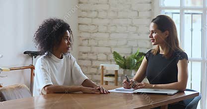 Young female hr manager holding job interview with african applicant.