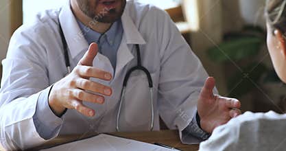 Male doctor consult handshake female patient at medical appointment, closeup