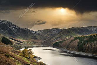Stunning Autumn Fall landscape of Hawes Water with epic lighting and dramatic sunlight in Lake District
